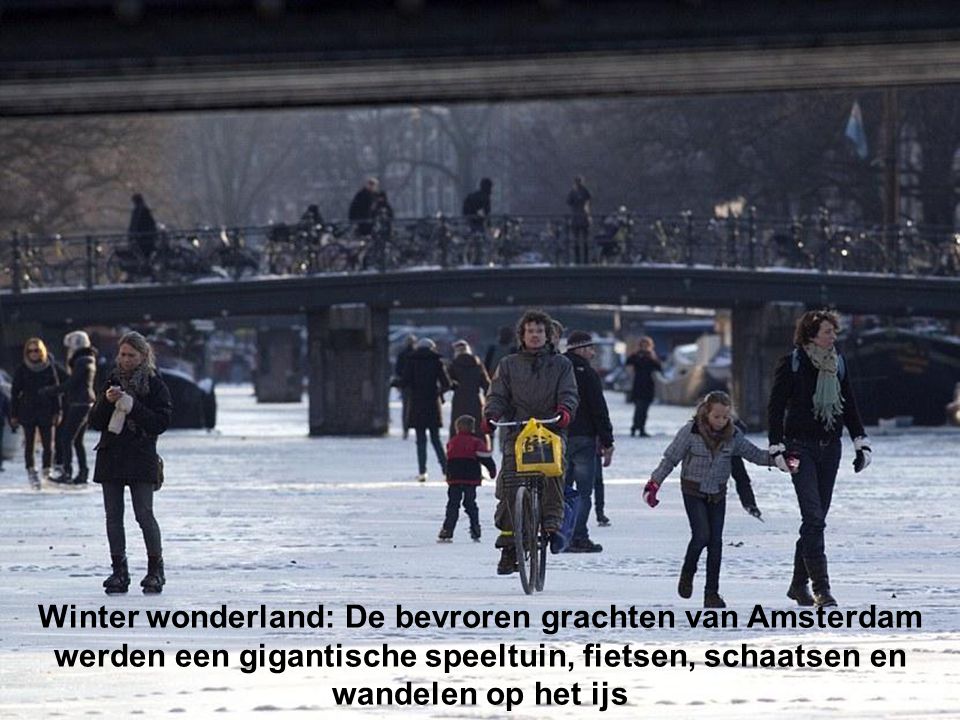 Amsterdam: Mensen lopen over de bevroren grachten, de grachten zijn gesloten voor commerciële scheepvaart